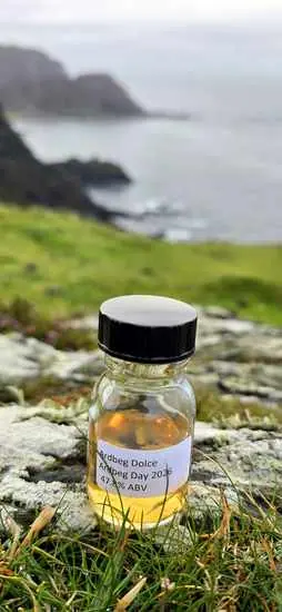 Muestra de whisky Ardbeg Dolce sobre una roca frente al mar de Islay