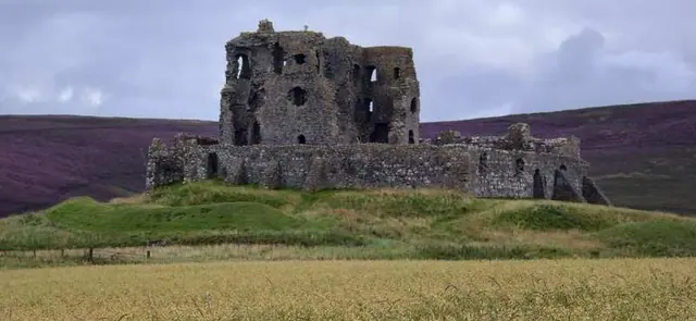 Ruinas de un castillo escocés rodeadas de brezo en flor