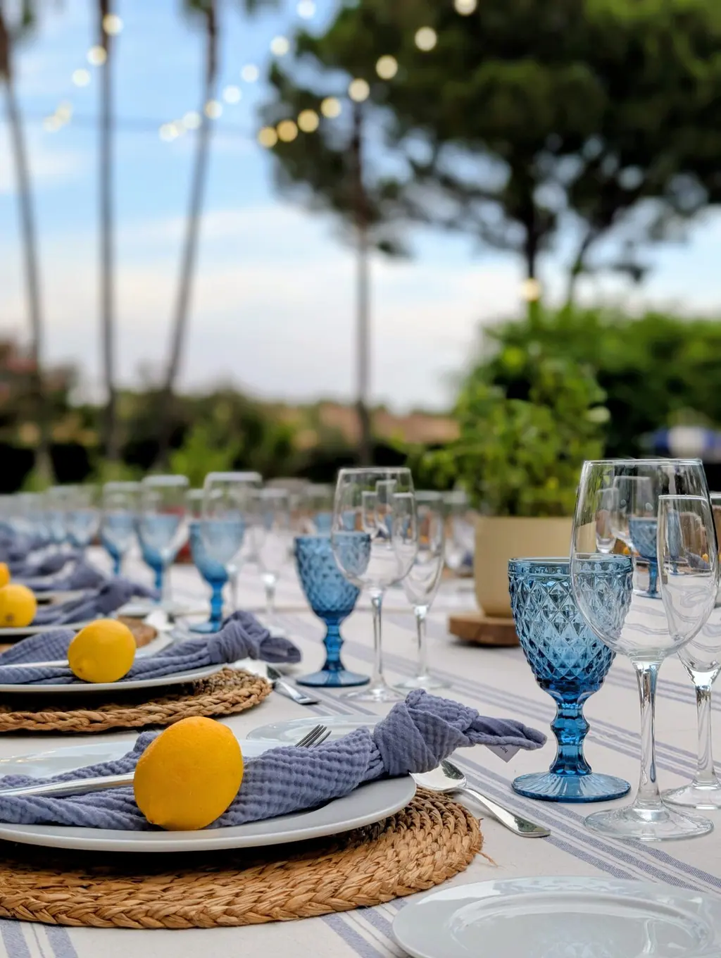 Mesa larga puesta en el jardín de Villa Paula bajo las guirnaldas de luces