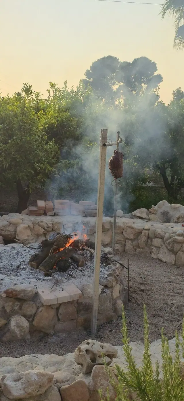 Barbacoa de brasa encendida en el jardín de Villa Paula