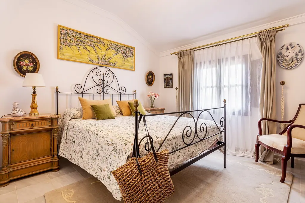 Dormitorio de forja con flores en Villa Paula