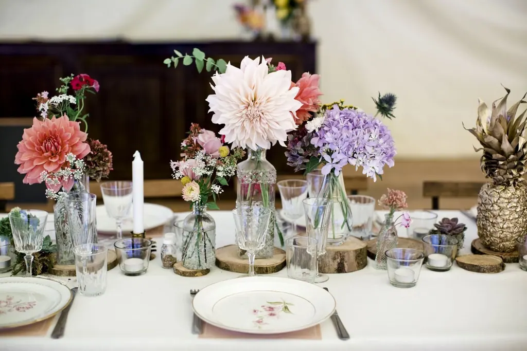 Mesa del cenador de Villa Paula con flores frescas y velas