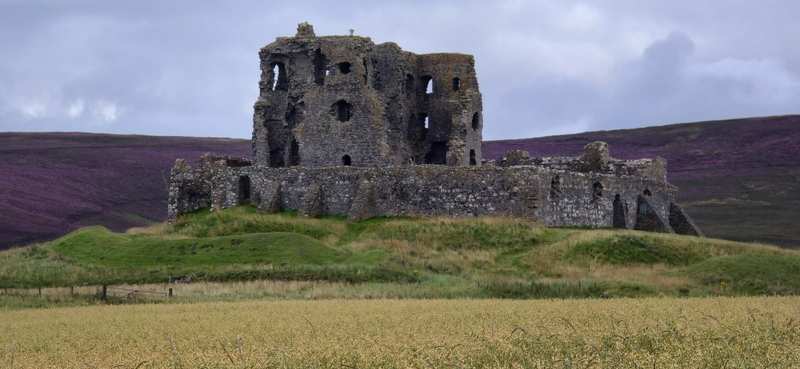 Ruinas de un castillo escocés rodeadas de brezo en flor