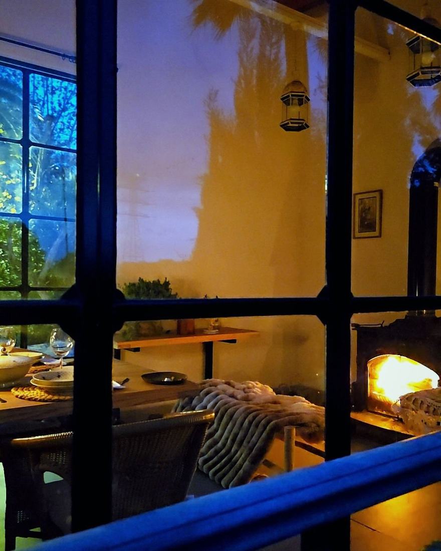 El Senador, el comedor del grupo, con su chimenea de le&ntilde;a propia al atardecer, mesa puesta y ventanales franceses al jard&iacute;n