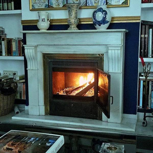 Chimenea de m&aacute;rmol de la sala de billar de Villa Paula, encendida