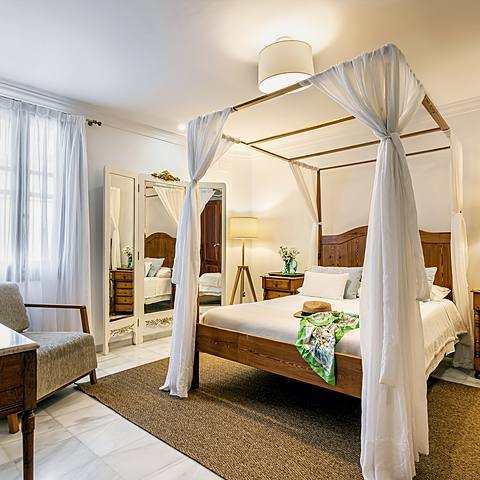 Habitaci&oacute;n Blanca de Villa Paula, con cama de dosel y armario antiguo tallado a mano