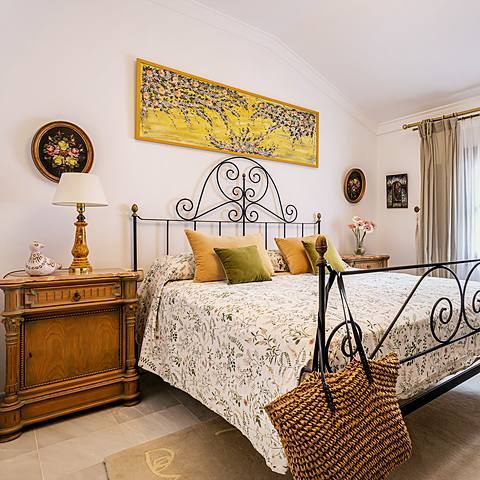 Habitaci&oacute;n Flores de Villa Paula, con cuadro floral sobre la cama y platos decorativos en la pared
