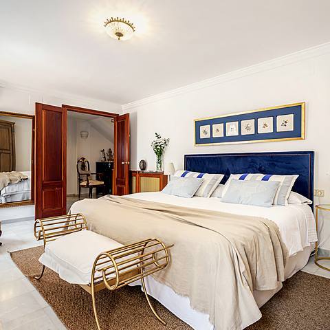 Habitaci&oacute;n Mediterr&aacute;nea de Villa Paula, en tonos azules y blancos con cer&aacute;micas de flores sobre la cama