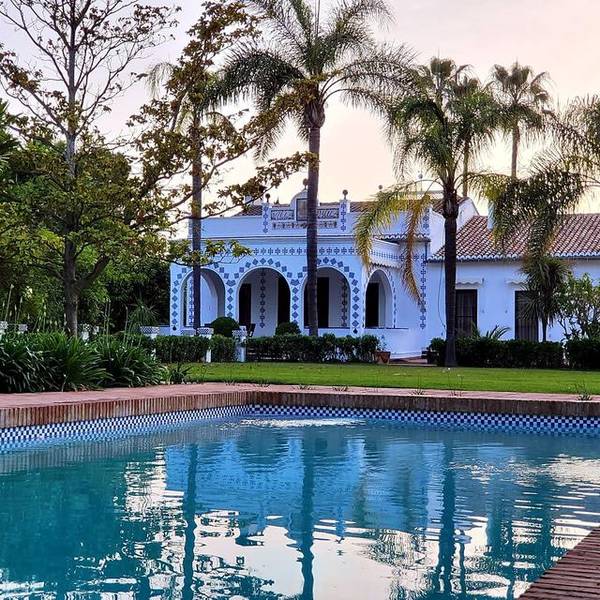 Fachada de Villa Paula con la piscina en primer plano al atardecer