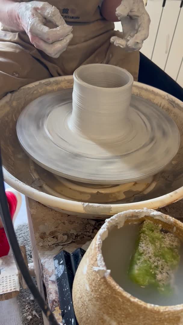Pieza de barro levantándose en el torno del obrador de cerámica