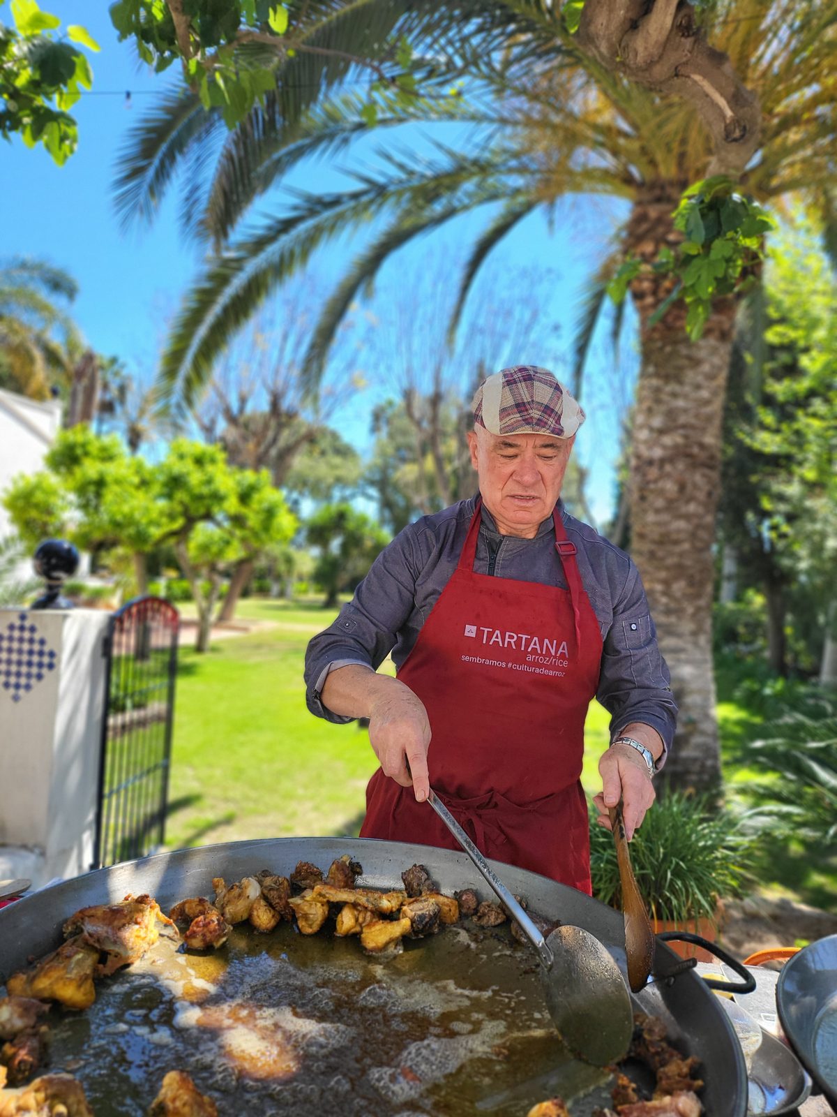Cocinero preparando arroz en el jardín de Villa Paula, Valencia