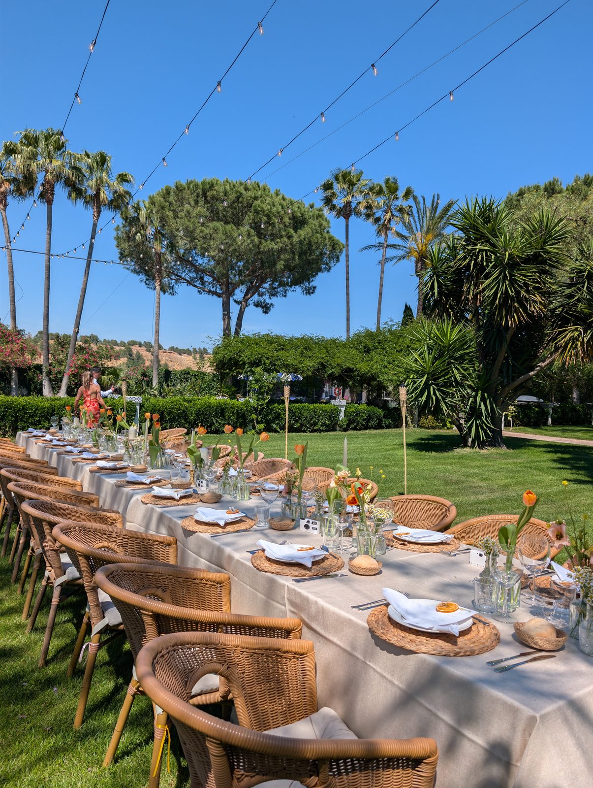 Mesa larga puesta en el jardín de Villa Paula para una celebración de grupo