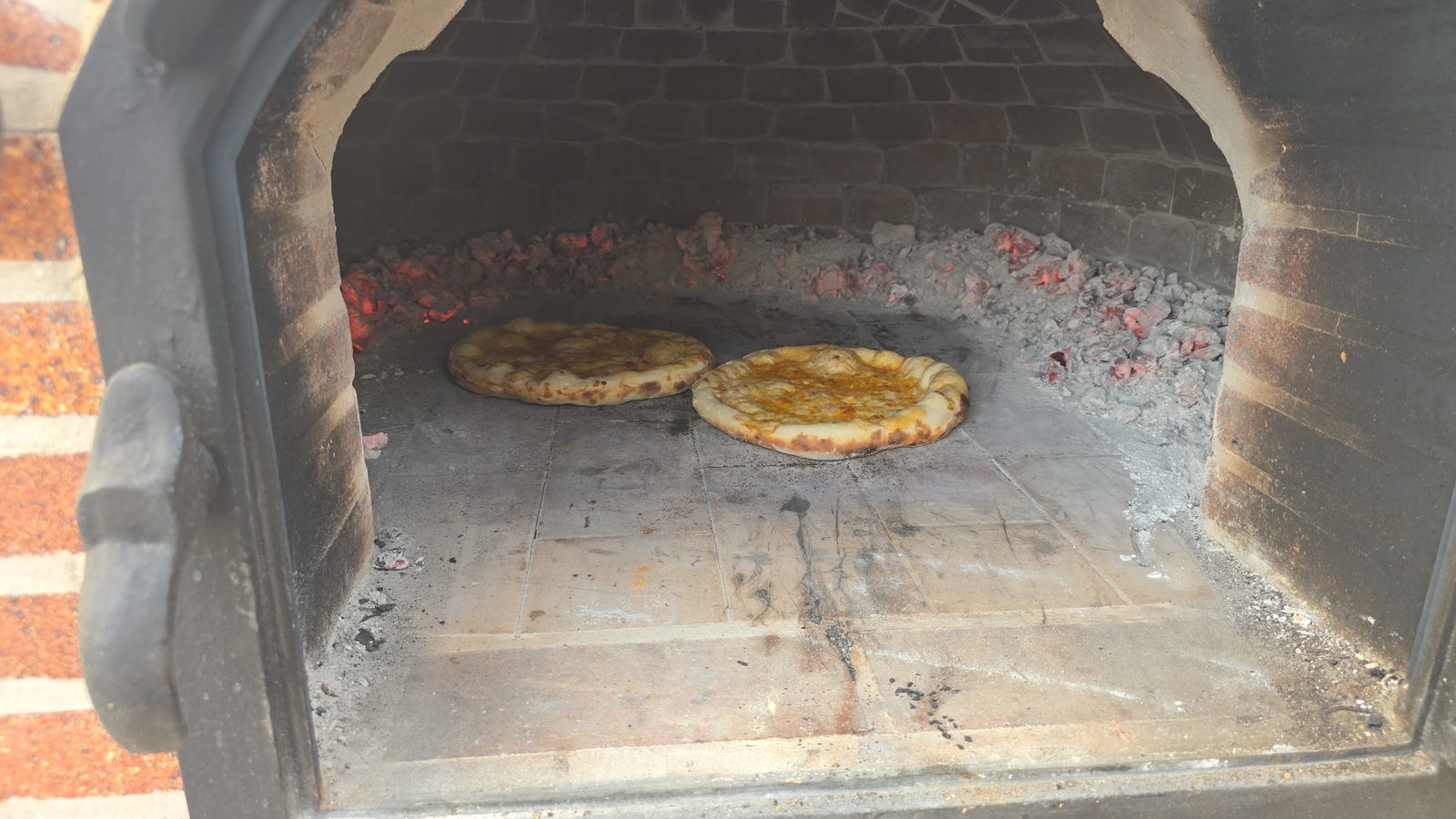 Pizza saliendo del horno de barro de Villa Paula